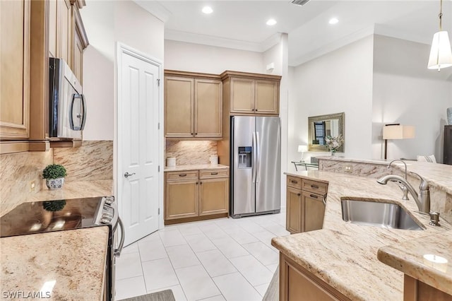 kitchen with stainless steel appliances, sink, light stone counters, and decorative light fixtures