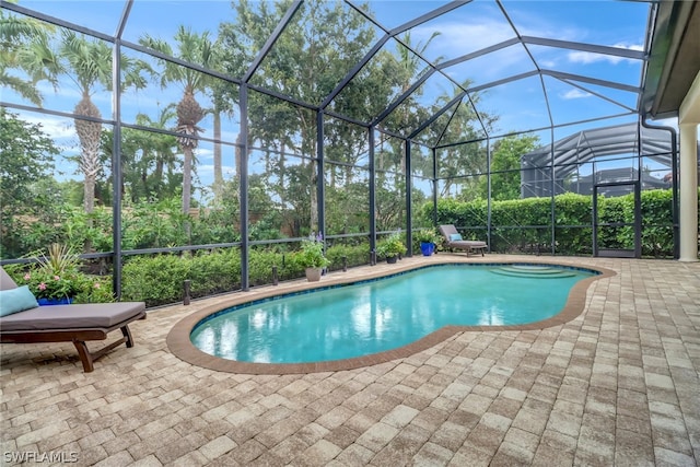 view of pool with a patio and glass enclosure