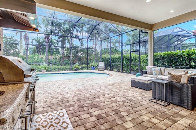 view of swimming pool with an outdoor kitchen, an outdoor living space, and a patio