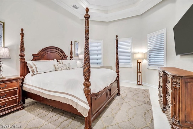 bedroom with ornamental molding and a tray ceiling