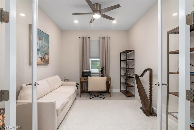 office area with french doors, ceiling fan, and light carpet