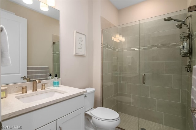 bathroom with vanity, an enclosed shower, and toilet