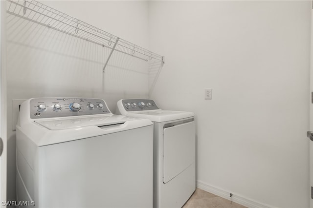 laundry room with light tile flooring and washing machine and dryer