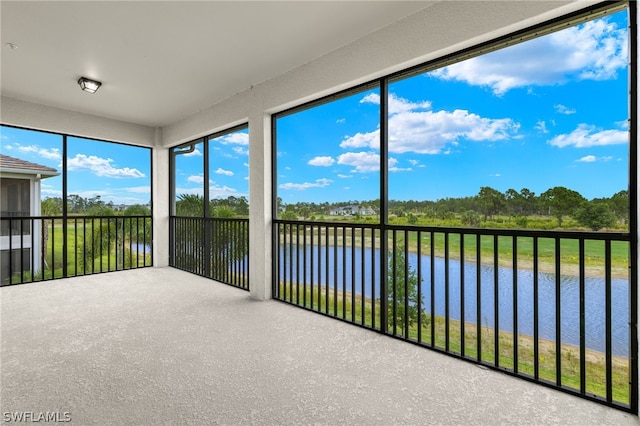 unfurnished sunroom featuring a water view