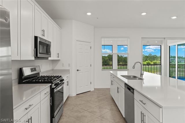 kitchen featuring white cabinets, appliances with stainless steel finishes, sink, and light tile floors