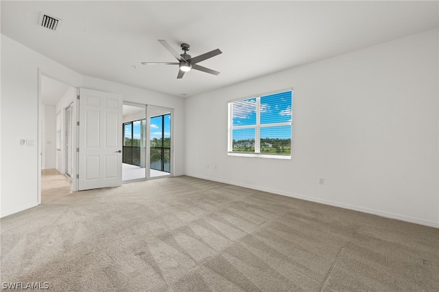 carpeted spare room with ceiling fan