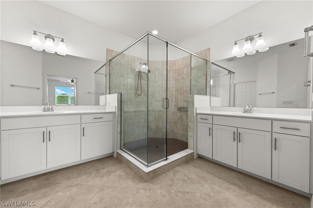 bathroom featuring tile floors, a shower with door, and vanity with extensive cabinet space