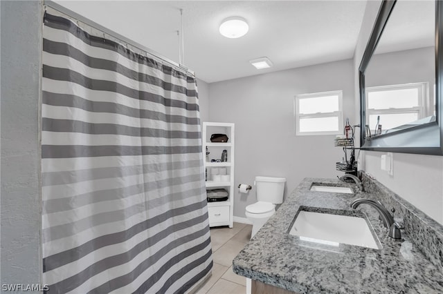 bathroom featuring toilet, tile flooring, and dual vanity