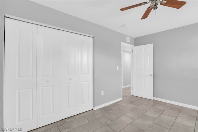 unfurnished bedroom with a closet, ceiling fan, and light tile floors