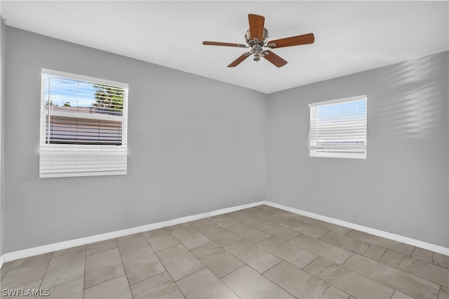 tiled spare room featuring plenty of natural light and ceiling fan