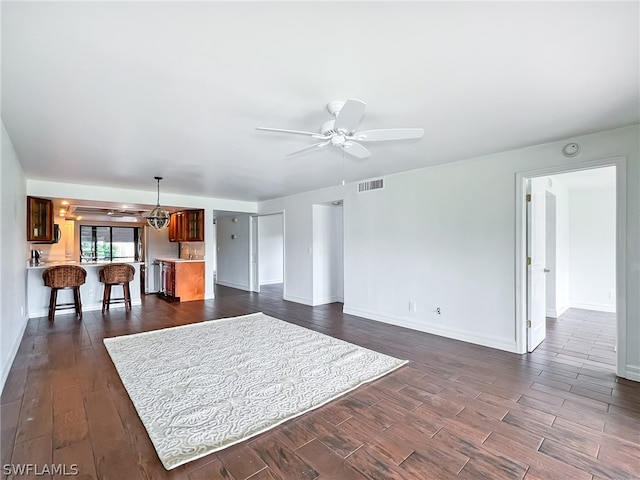 unfurnished living room with dark wood-type flooring and ceiling fan