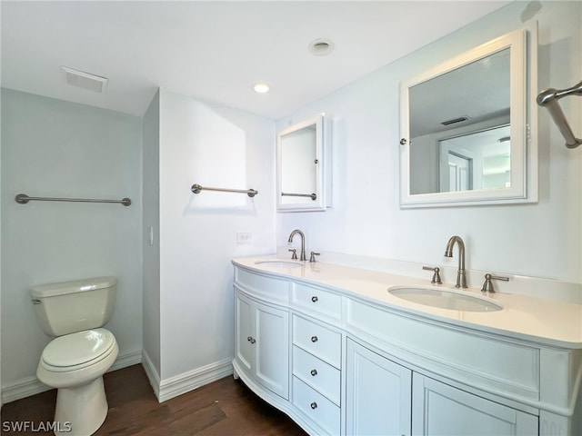 bathroom featuring wood-type flooring, double vanity, and toilet