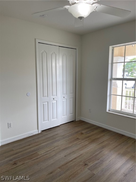 unfurnished bedroom with dark wood-type flooring and ceiling fan