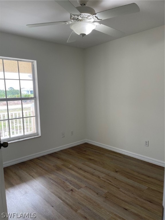 spare room with dark hardwood / wood-style flooring and ceiling fan