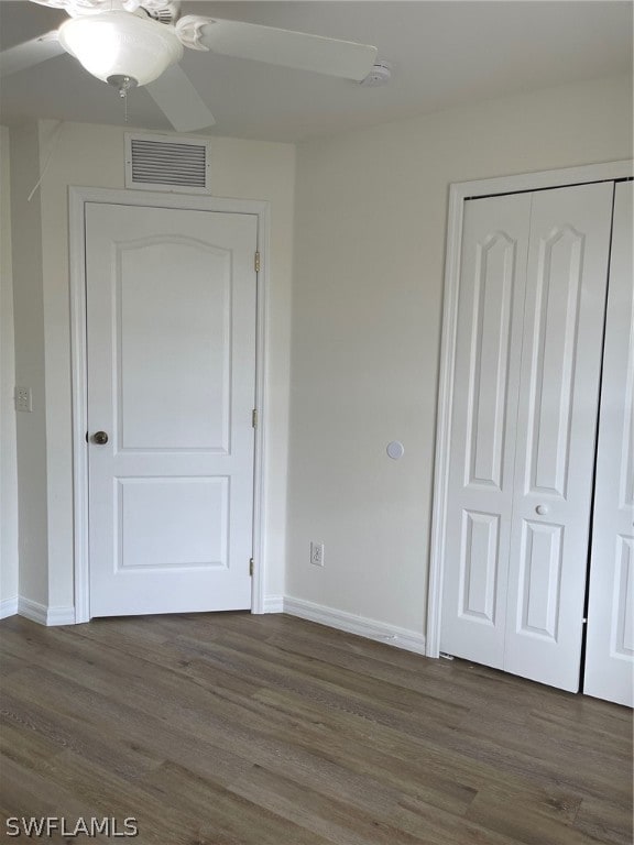 unfurnished bedroom featuring dark hardwood / wood-style floors, ceiling fan, and a closet