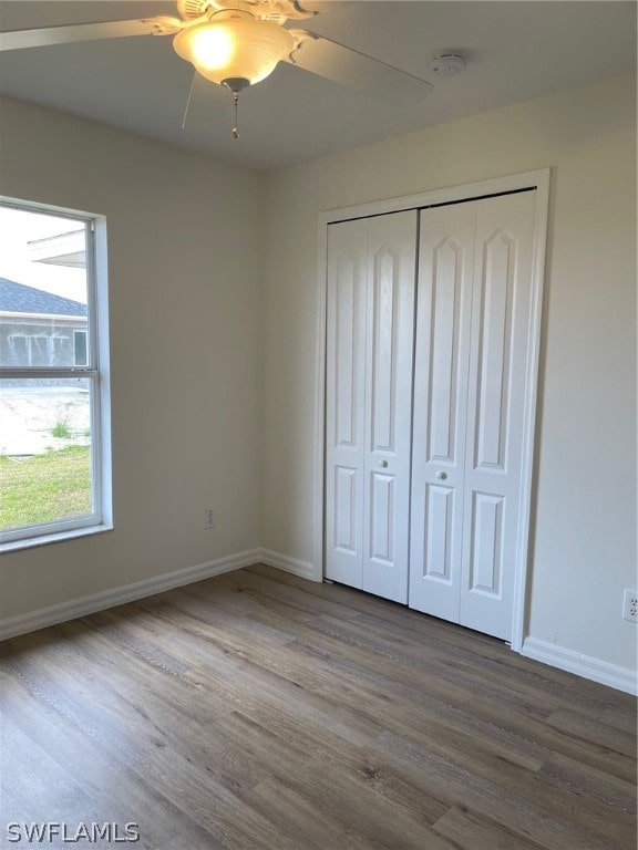 unfurnished bedroom with a closet, ceiling fan, and hardwood / wood-style floors