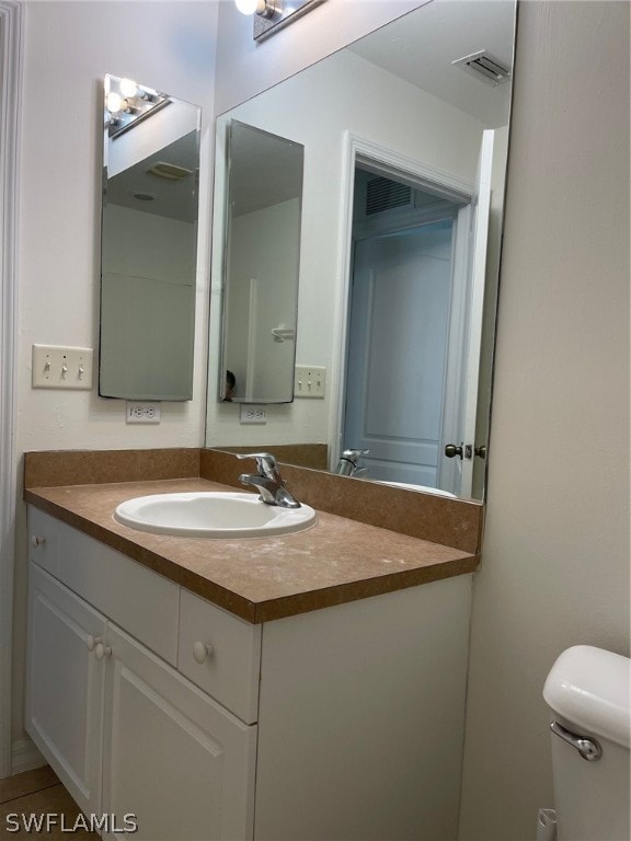 bathroom with vanity with extensive cabinet space and toilet