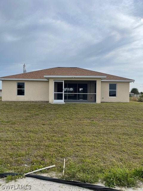 rear view of house featuring a lawn