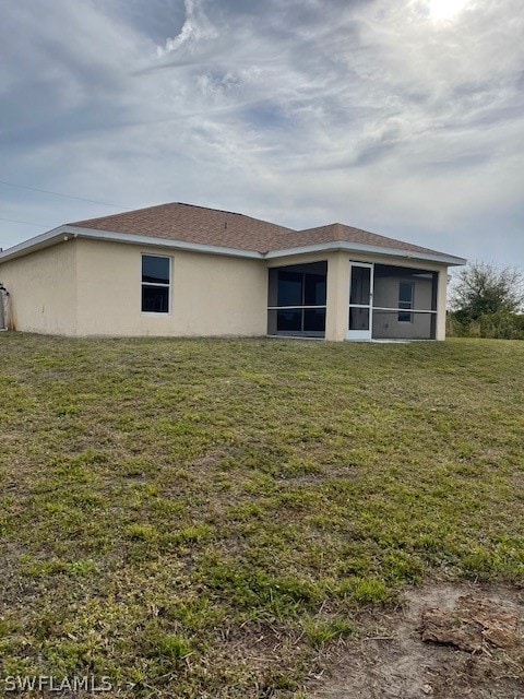 rear view of house featuring a lawn