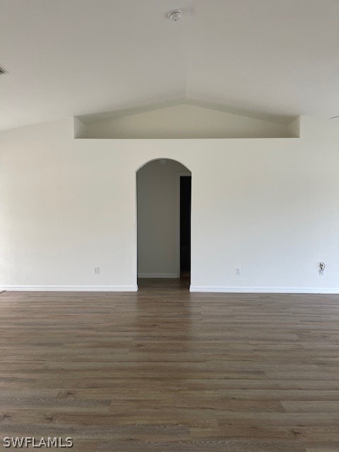 spare room featuring dark hardwood / wood-style floors and lofted ceiling