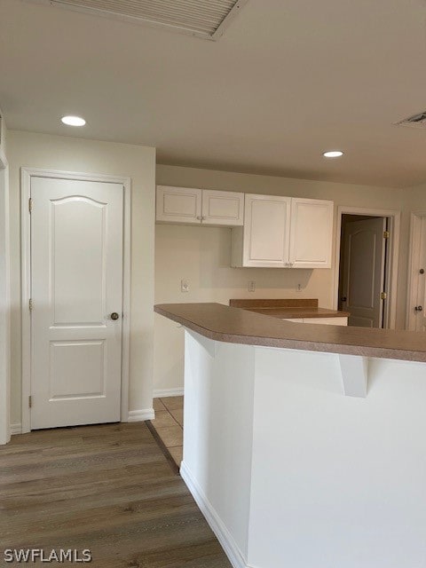 kitchen featuring hardwood / wood-style floors and white cabinetry