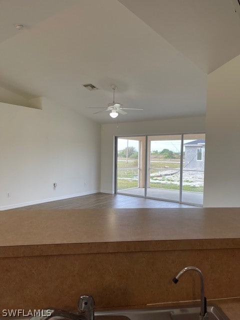 unfurnished room with ceiling fan and vaulted ceiling