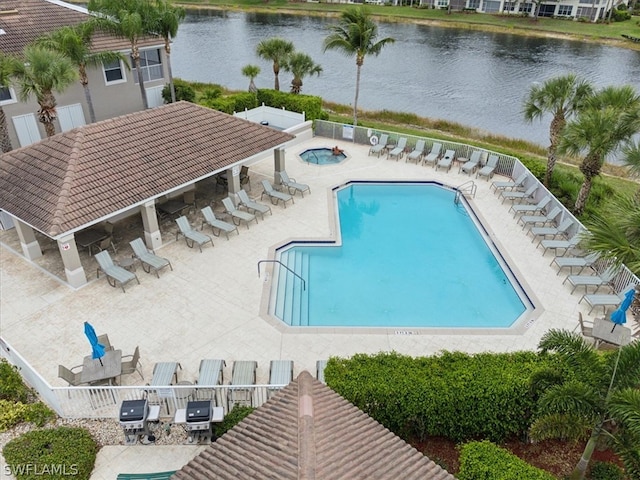 view of swimming pool with a water view and a patio area