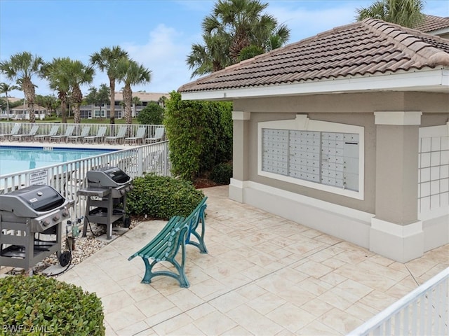 view of patio / terrace featuring area for grilling, mail boxes, and a community pool