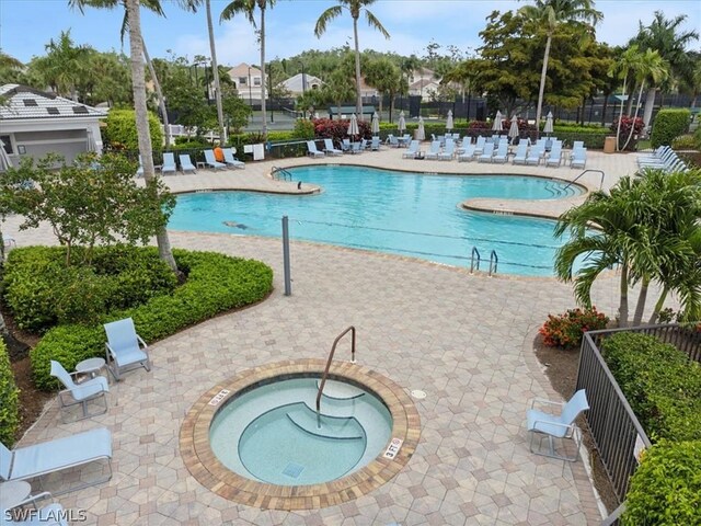 view of pool with a patio and a hot tub