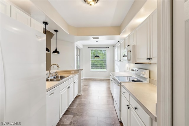 kitchen with white cabinetry, pendant lighting, and white appliances