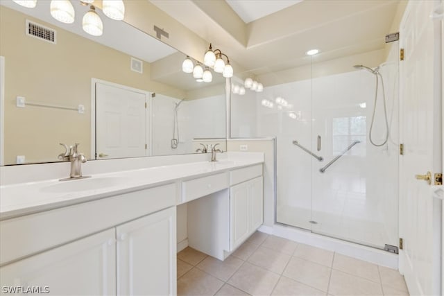 bathroom with a shower with shower door, double vanity, and tile patterned floors