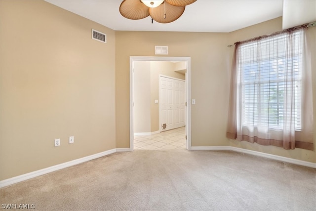 carpeted spare room featuring ceiling fan