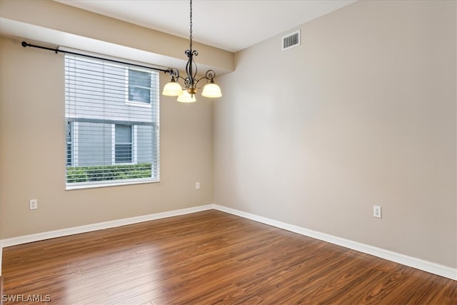 unfurnished room with a notable chandelier and wood-type flooring