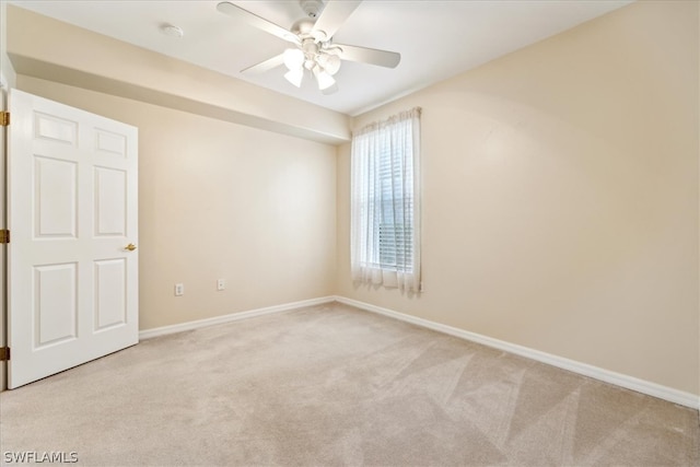 carpeted spare room featuring ceiling fan