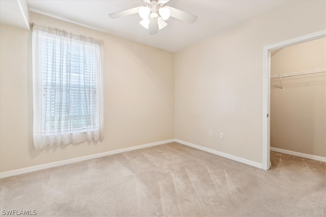 unfurnished bedroom featuring carpet, multiple windows, and ceiling fan