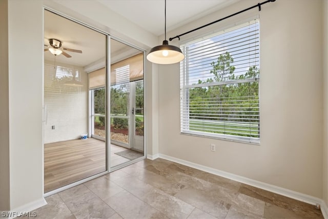 unfurnished dining area featuring light tile patterned flooring, a healthy amount of sunlight, and ceiling fan