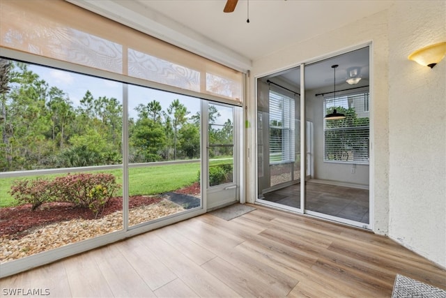 unfurnished sunroom with ceiling fan