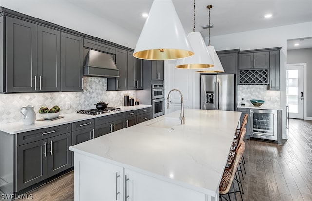 kitchen with backsplash, premium range hood, a large island, and stainless steel appliances