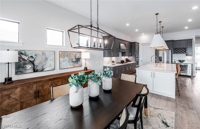 dining area with wine cooler, wood-type flooring, and sink