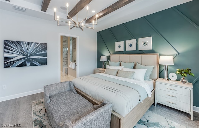 bedroom with an inviting chandelier, beamed ceiling, hardwood / wood-style floors, and ensuite bathroom