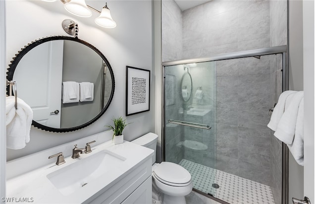 bathroom featuring walk in shower, vanity, and toilet