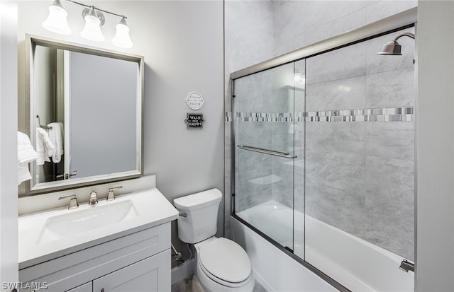 full bathroom featuring enclosed tub / shower combo, oversized vanity, and toilet