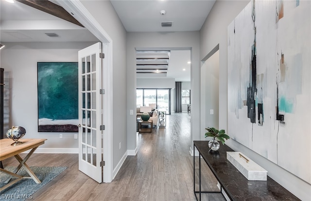 foyer with beamed ceiling, french doors, and light hardwood / wood-style floors