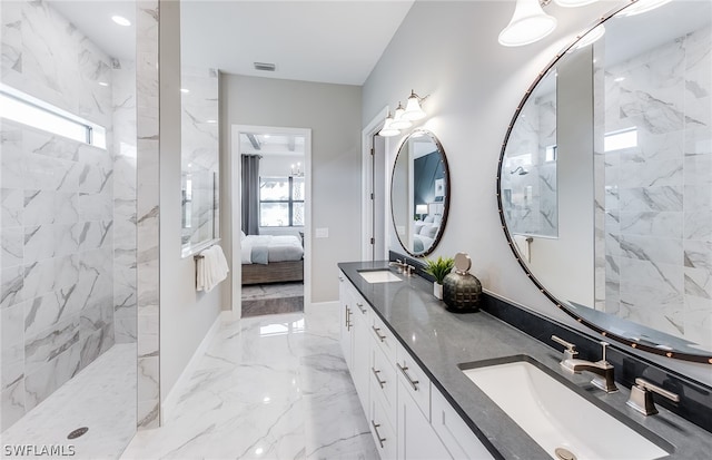 bathroom with tiled shower, dual bowl vanity, and tile floors