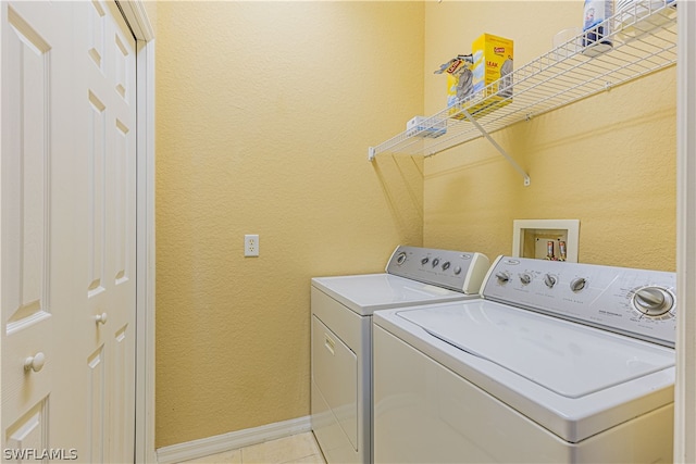 washroom with washer hookup, light tile floors, and washing machine and clothes dryer