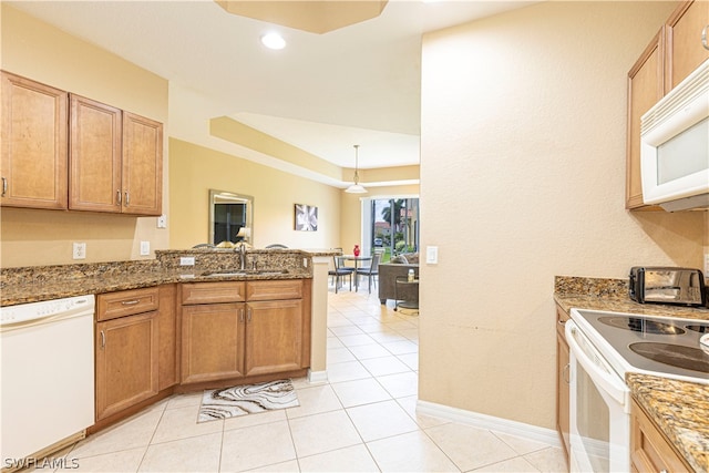 kitchen with sink, white appliances, kitchen peninsula, and light tile floors