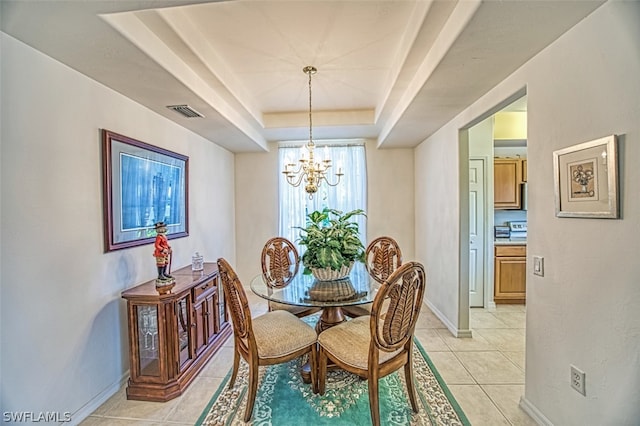 tiled dining room with a tray ceiling and a notable chandelier