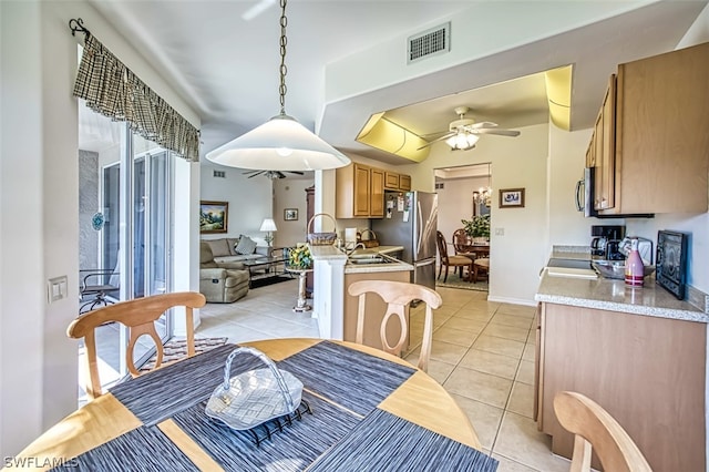 dining area with ceiling fan, sink, and light tile floors