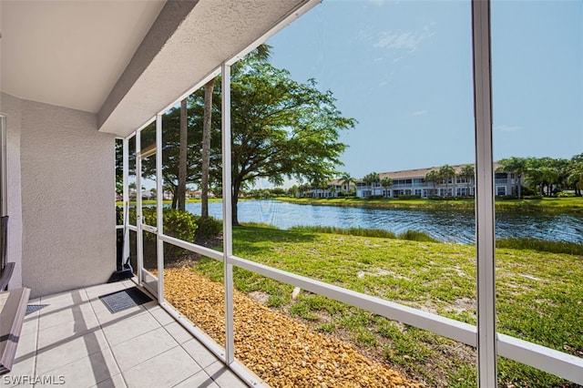 unfurnished sunroom featuring a water view