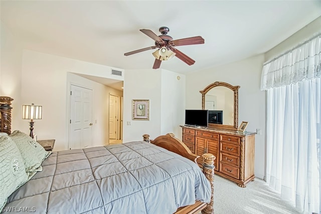 bedroom with a closet, ceiling fan, and light colored carpet